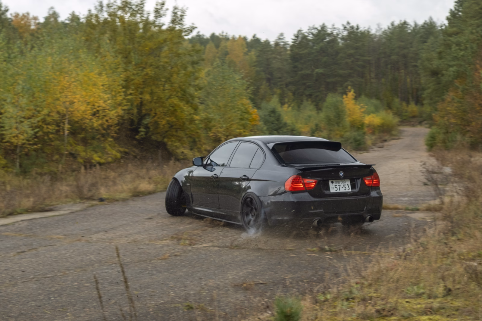 Juodas sportinis automobilis trasoje.